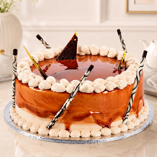 Chocolate cake with white frosting and decorative elements on a marble surface.