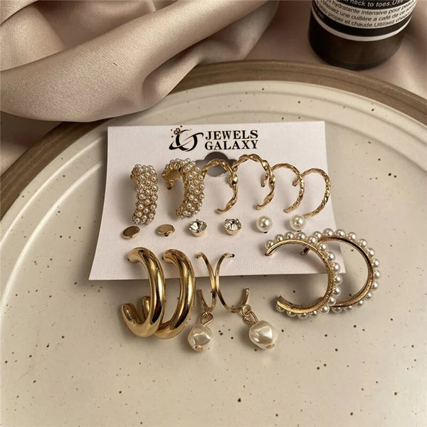 Set of gold and pearl earrings on a 'Jewels Galaxy' card with a beige fabric background.
