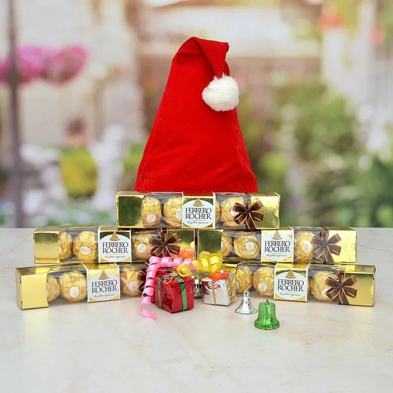 Ferrero Rocher chocolates with a Santa hat on a blurred garden background