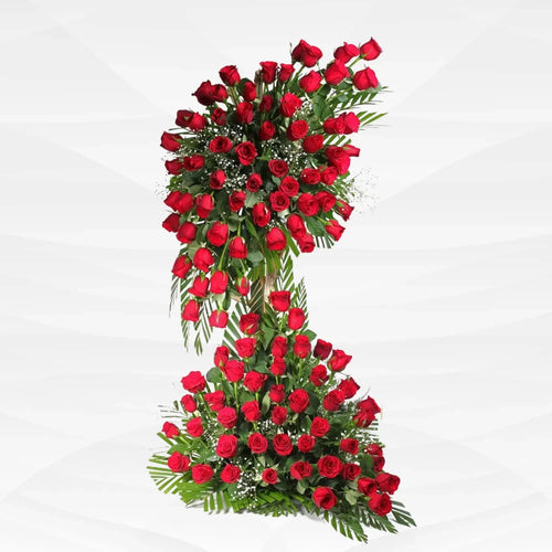 Large two-tier red rose flower arrangement with green leaves on white background