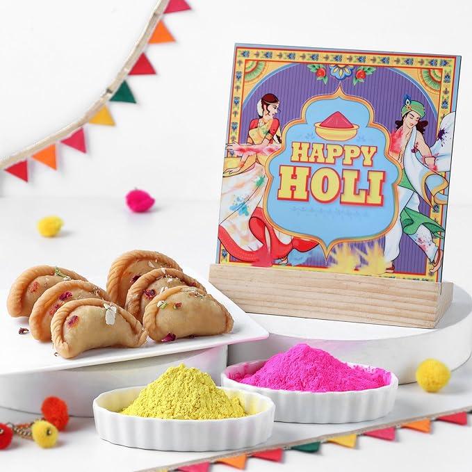 Holi-themed card with yellow and pink powders and cookies on a white background.