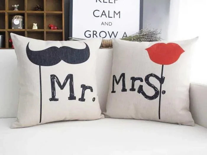 Two decorative pillows with 'Mr.' and 'Mrs.' text on a couch.