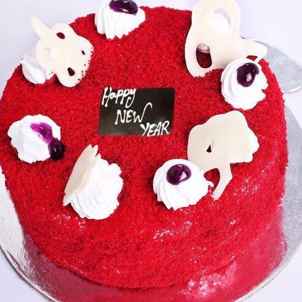 Red cake with white decorations and a 'Happy New Year' sign on a clear background