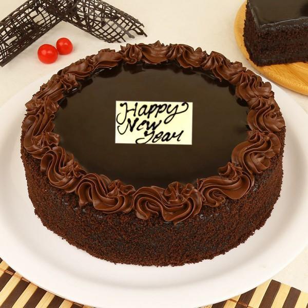 Chocolate cake with 'Happy New Year' message on a white plate