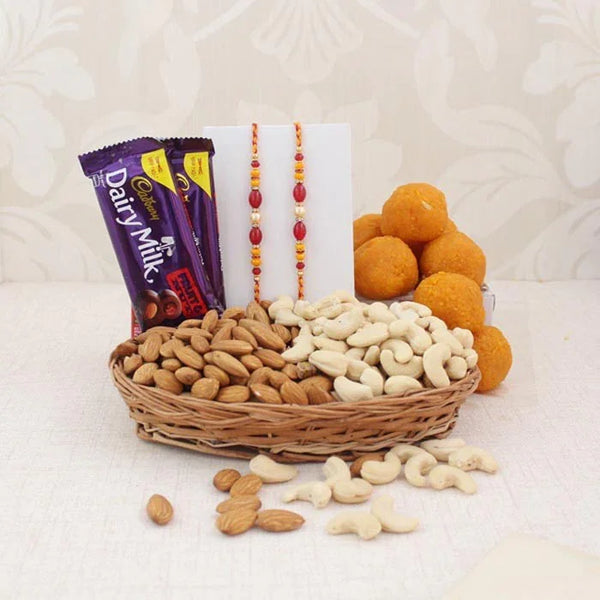 Basket of nuts, Cadbury Dairy Milk chocolate, and oranges on a white background