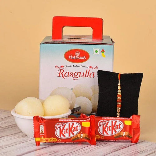 Hakdiram's Rasgulla with Kit Kat bars and a Rakhi on a wooden surface.