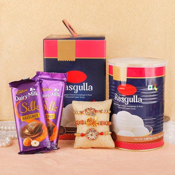 Cadbury Dairy Milk chocolates, a box of Rasgulla, a can of Rasgulla, and a decorative item on a beige background.