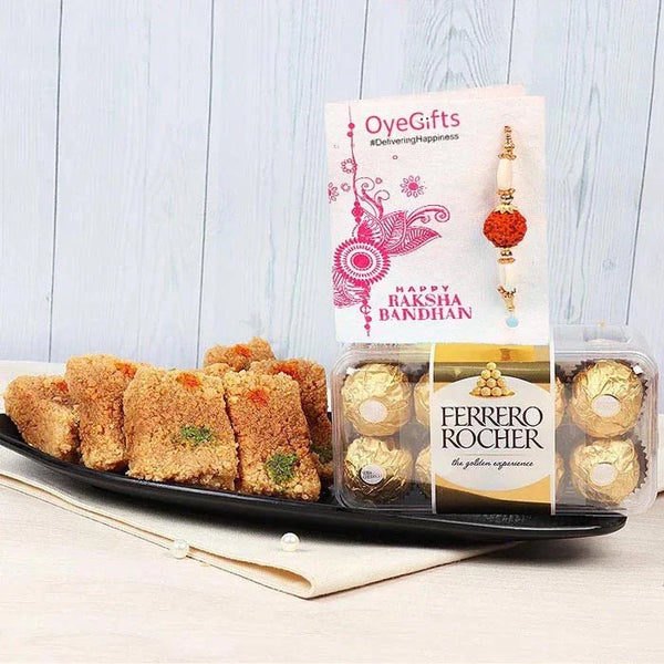 Ferrero Rocher chocolates and a plate of cookies with a 'Happy Raksha Bandhan' card on a light wooden background.