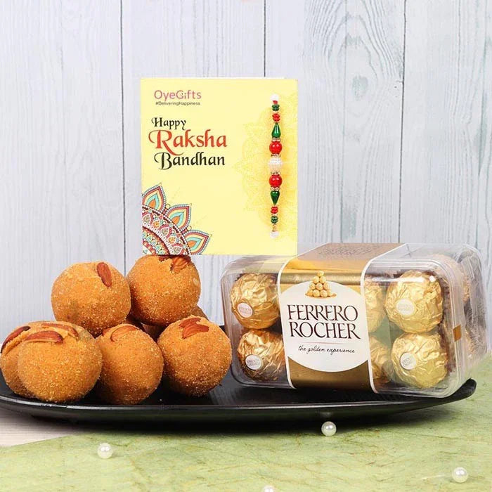 Ferrero Rocher chocolates and ladoos on a plate with a Raksha Bandhan card in the background.