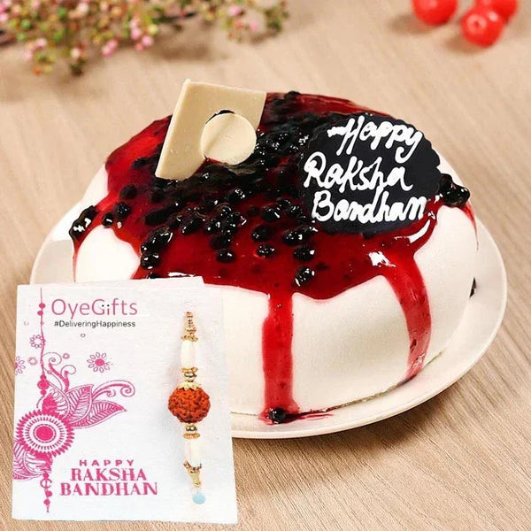 Cake with 'Happy Raksha Bandhan' decoration on a plate, accompanied by a card and rakhi.
