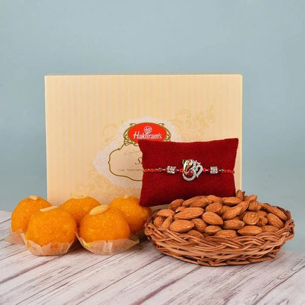 Wooden gift box with Rakhi, almonds, and tangerines on a wooden surface.
