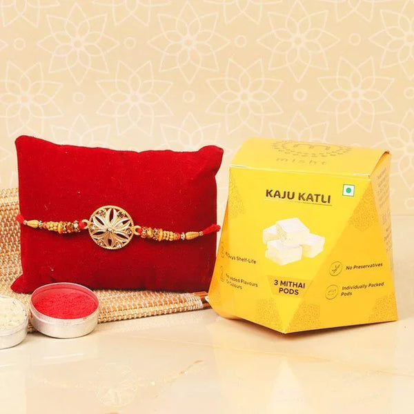 Red pouch with a decorative thread, yellow Kaju Katli box, and red powder container on a beige background