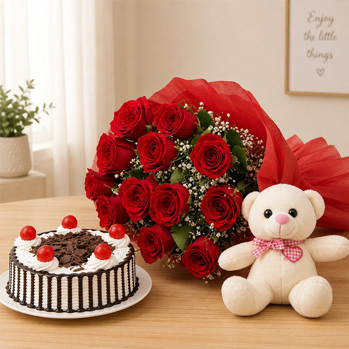 Bouquet of red roses, chocolate cake with red berries, and teddy bear on a wooden table.