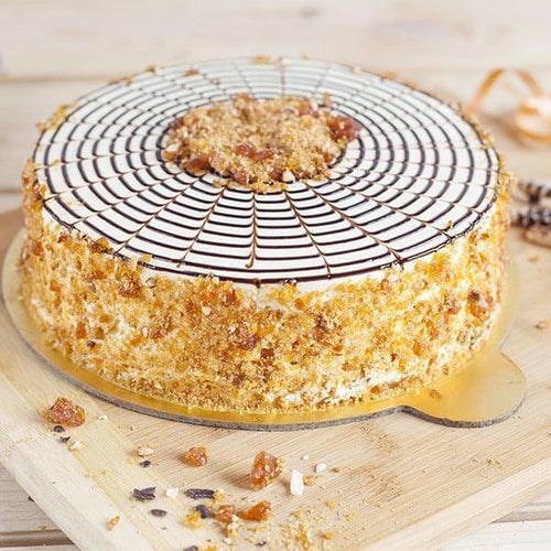 Close-up of a layered cake with a decorative top on a wooden board.