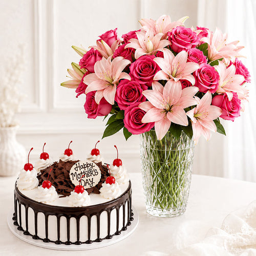Chocolate cake with 'Happy Mother's Day' and a bouquet of pink and white flowers in a vase.