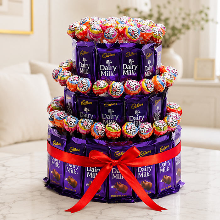 Cadbury Dairy Milk chocolate tower with colorful lollipops on a marble surface.
