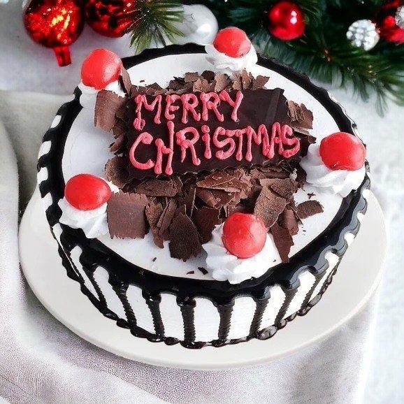 Christmas Black Forest cake with cream, cherries, chocolate shavings and festive decoration