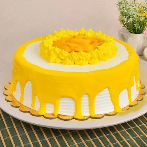 Creamy layered mango cake with yellow frosting and fresh mango slices on top, ideal for celebrations.
