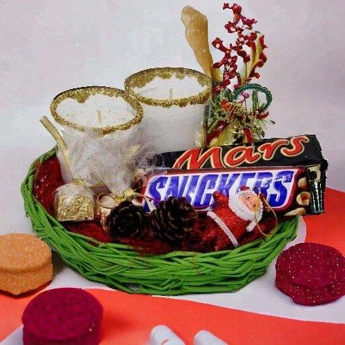 Christmas gift basket with chocolate bars, candles, pinecone, and festive decorations