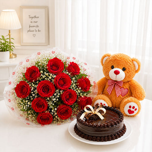 Bouquet of red roses, chocolate cake, and teddy bear on a table with a decorative background.