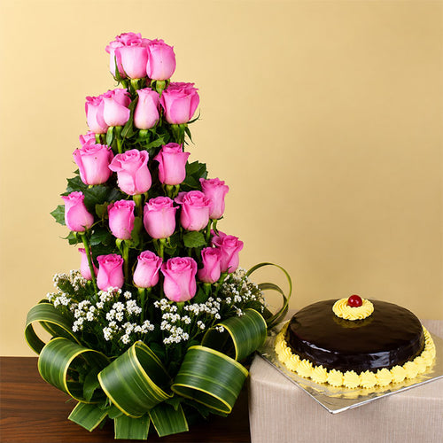 Tall tower of pink roses with a chocolate cake on a beige background