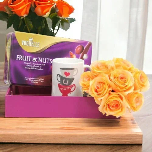 Gift hamper with box of fruit and nut chocolates, yellow roses, and a 'mom' coffee mug