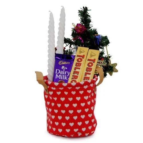 Gift hamper with Christmas tree, candles, Dairy Milk, and Toblerone in red heart basket