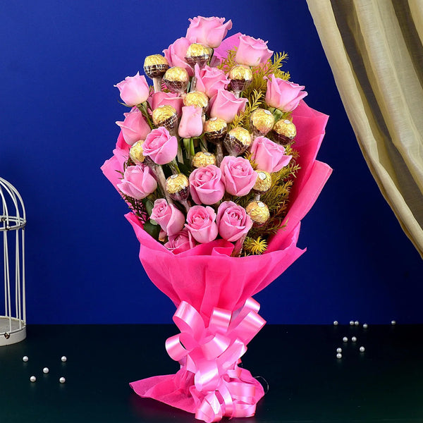 Bouquet of pink roses with gold accents wrapped in pink paper against a blue background