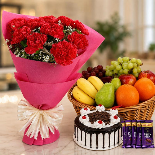 Bouquet of red flowers, cake, and fruit basket on a table.
