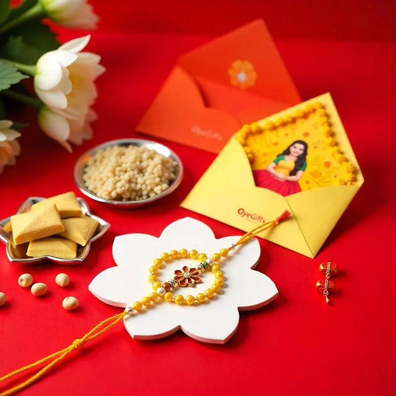 Rakhi with yellow thread, photo card, and sweets on a red background
