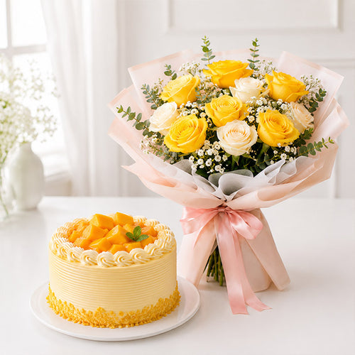 Yellow cake with fruit pieces and a bouquet of yellow and white roses on a white surface.