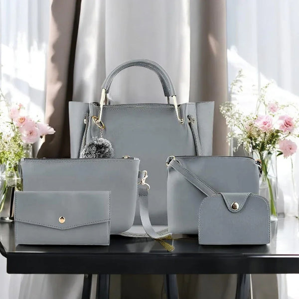 Set of gray handbags on a table with flowers in the background
