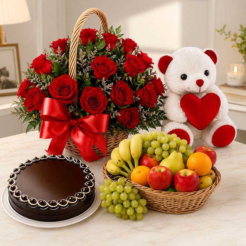 Bouquet of red roses, teddy bear with a heart, cake, and fruit basket on a table.