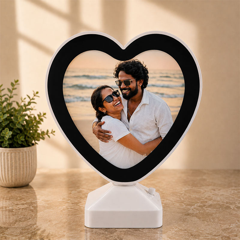 Heart-shaped photo frame with a couple on a beach displayed inside