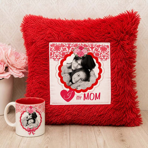 Red pillow with a photo of two people and 'I love my mom' text, next to a matching mug on a wooden surface.