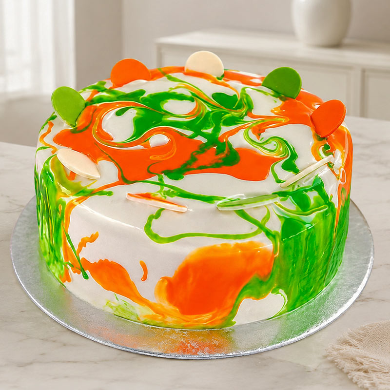 Decorative cake with orange and green swirls on a white surface