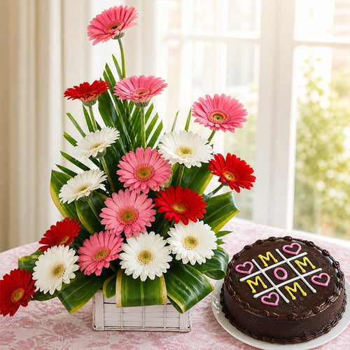 Bouquet of pink, red, and white flowers with a chocolate cake on a table.