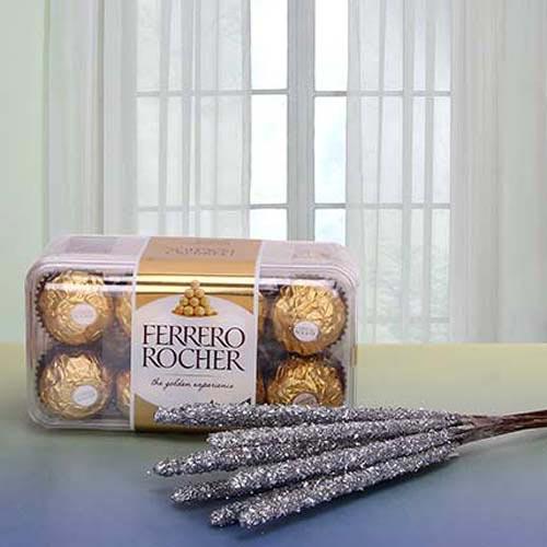 Ferrero Rocher chocolate gift box with decorative glitter sticks on a table