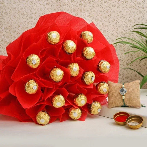Bouquet of red flowers with gold Ferrero Rocher chocolates, accompanied by a small decorative pillow and bowls.