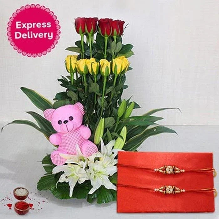 Floral arrangement with red and yellow roses, a pink teddy bear, and a red gift box on a white background.