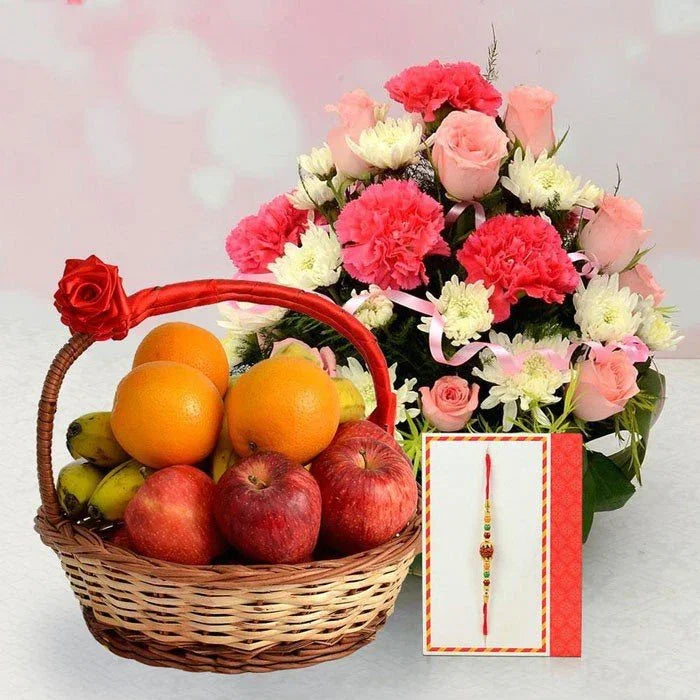 Basket of fruits with a bouquet of flowers and a card on a light pink background