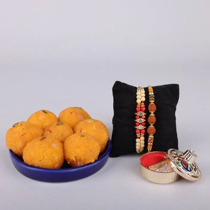 Decorative items including a plate of round snacks, a black pillow with bangles, and a small jewelry box on a light gray background.