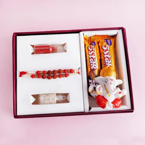 Gift box with candy, bracelet, and figurine on a pink background