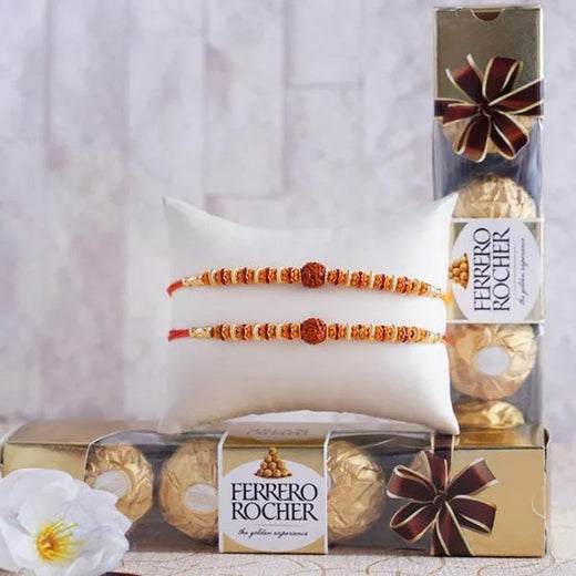 Ferrero Rocher chocolate box with two Rakhi on a white pillow against a light background