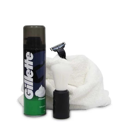 Men’s grooming kit with shaving foam, razor, brush, and towel on white background