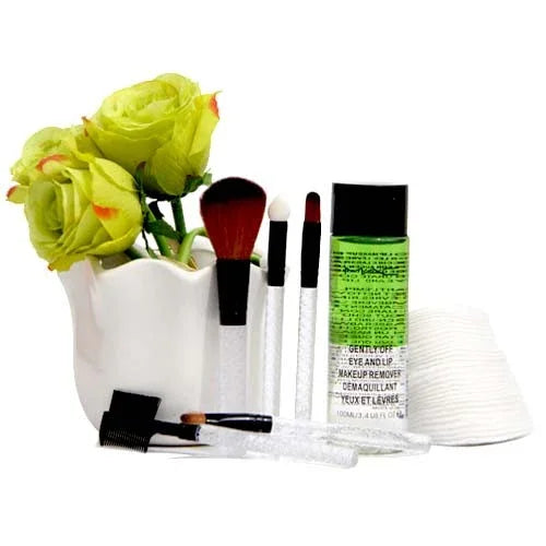 Makeup brush set, eye makeup remover, cotton pads, and yellow roses in a white vase