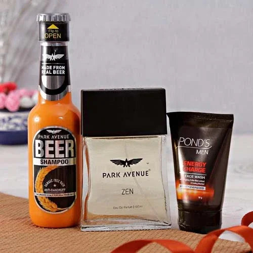 Men's grooming gift set with Park Avenue Beer Shampoo, Zen perfume, and Pond's face wash on table.