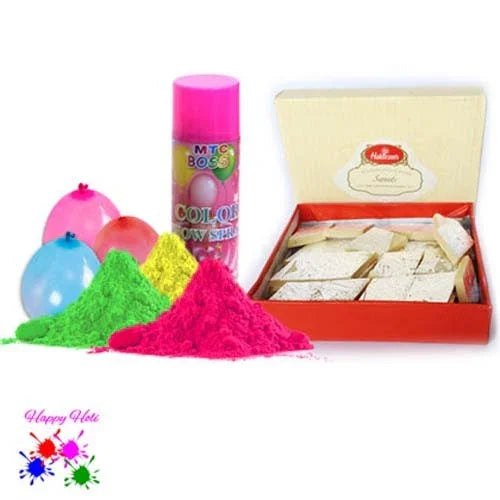 Colorful powder, balloons, and a box of Kaju Katli on a white background