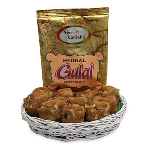 Basket of Indian sweets with a packet of herbal gulal for festive gift occasions
