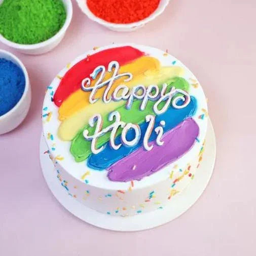Colorful cake with 'Happy Holi' text on a pink background